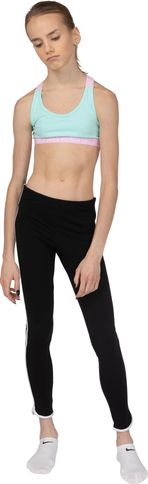 Front view of a tired teen girl in sportswear pouting