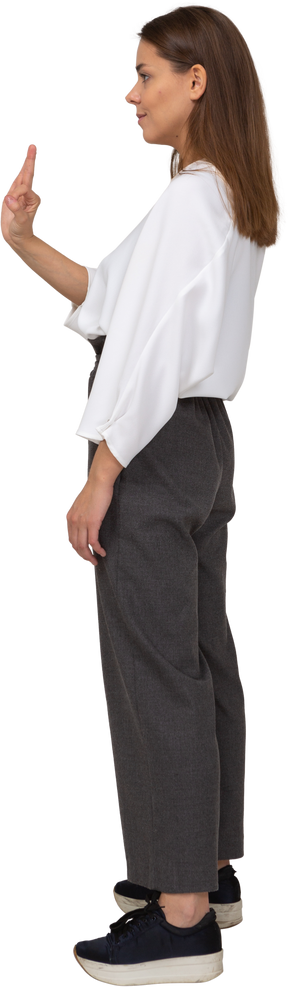 Vista lateral de una señorita en ropa de oficina mostrando gesto ok