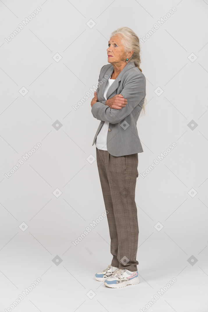 Side view of an old lady in suit posing with crossed arms