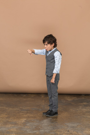 Side view of a boy in grey suit showing thumb down