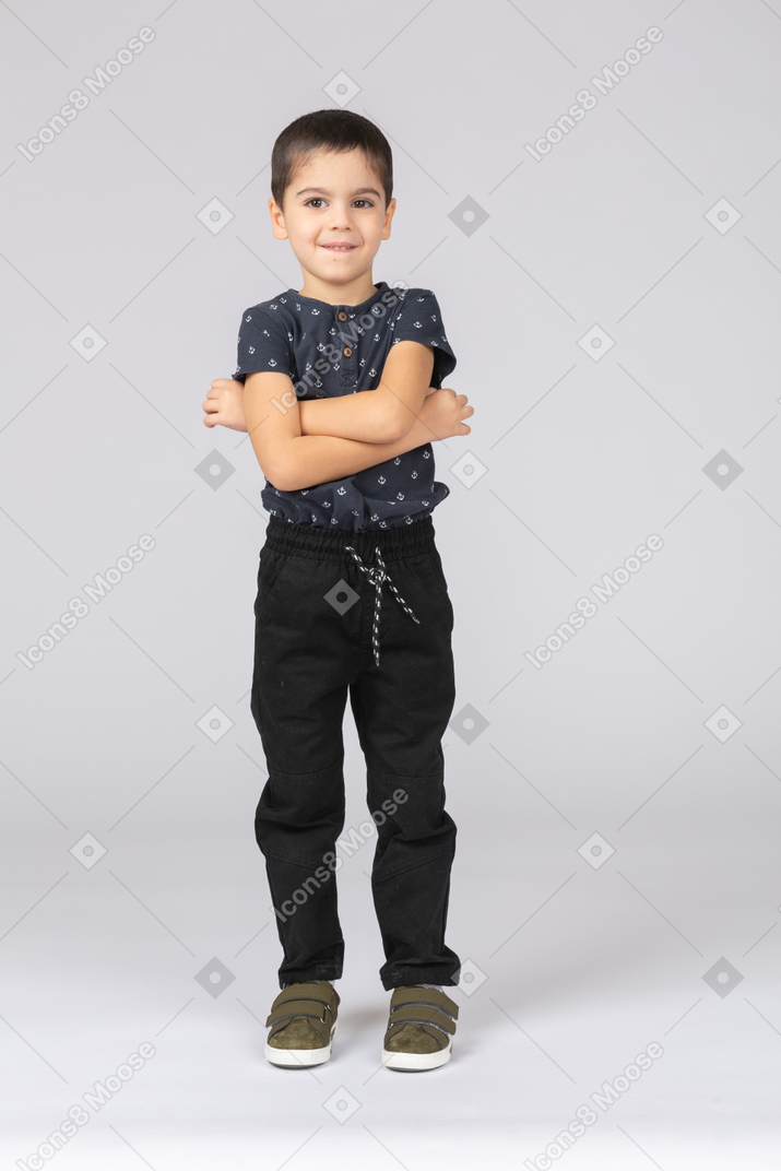一个可爱的男孩交叉双臂摆姿势的前视图