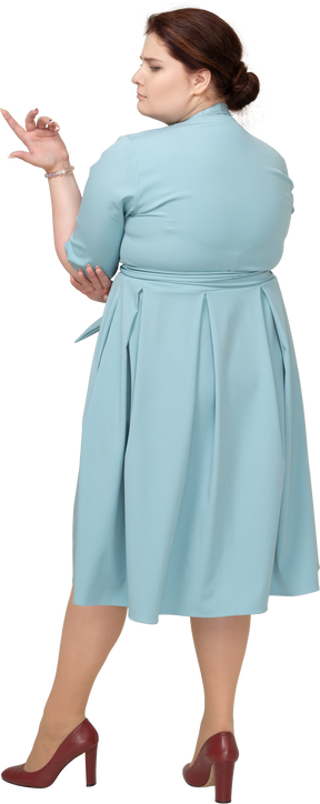 Rear view of a woman in blue dress posing