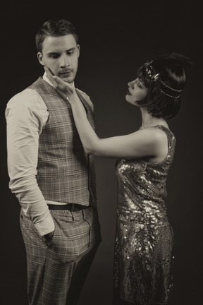 Hombre y mujer bien vestidos mirando el uno al otro aislado sobre fondo negro