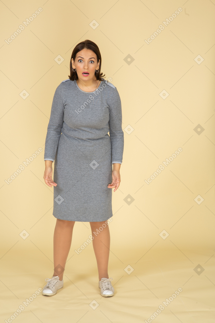 Mujer impresionada en vestido gris