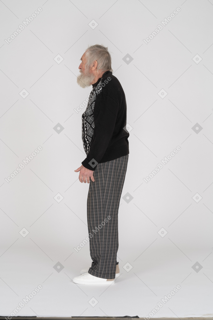 Vista lateral do homem idoso em pé com os braços ao lado