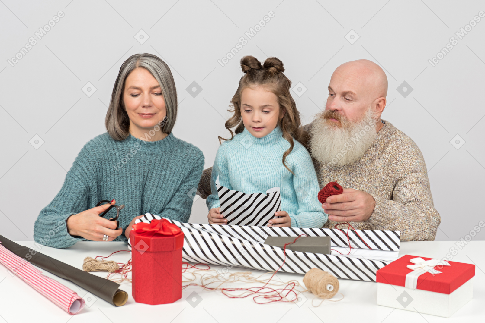 Grandpa putting christmas decor on granddaughter's hair while they wrapping presents