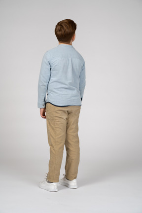 Punto di vista posteriore di un ragazzo in abiti casual che osserva in su