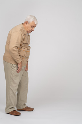 Side view of an old man in casual clothes looking down