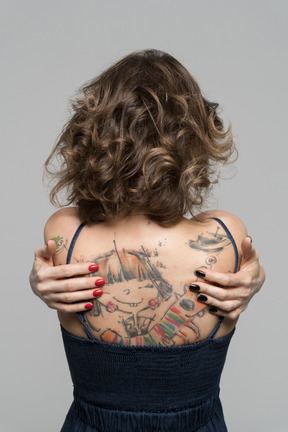 Ritratto di donna irriconoscibile con tatuaggio sulla schiena