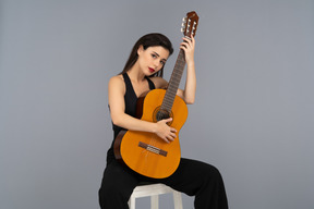 Jolie jeune femme posant avec une guitare