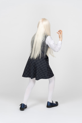 Back view of a schoolgirl raising her hand