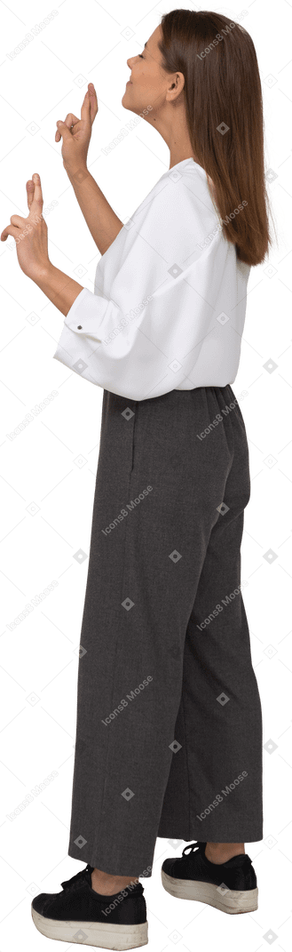 Vista lateral de una señorita en ropa de oficina cruzando los dedos