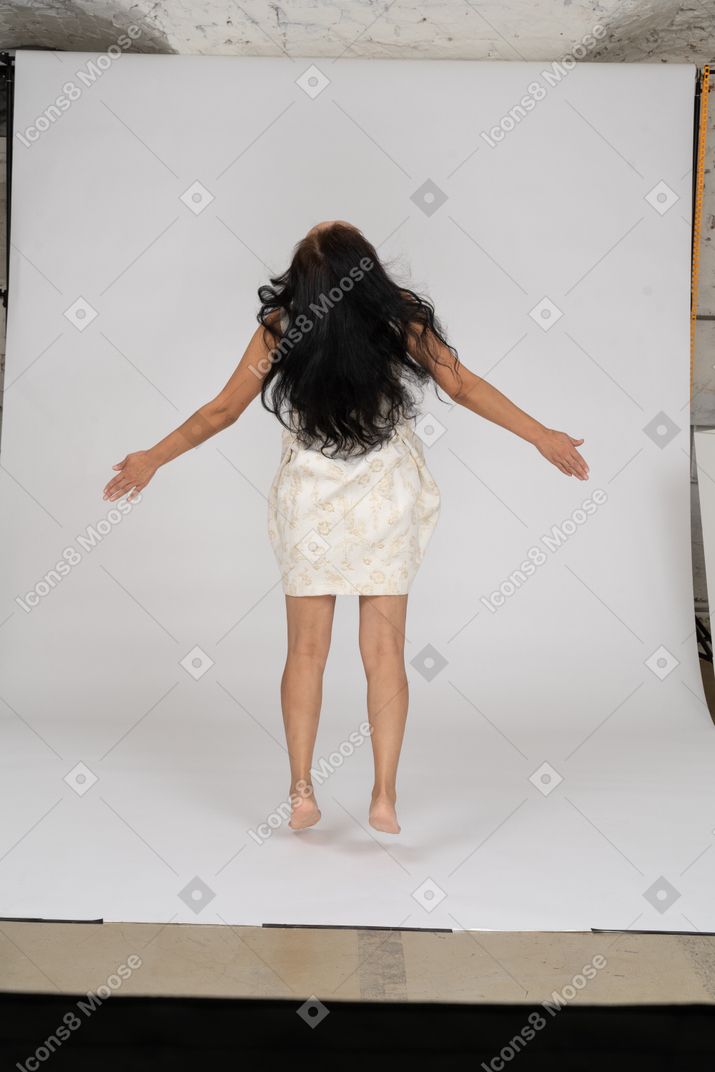 Femme en belle robe sautant