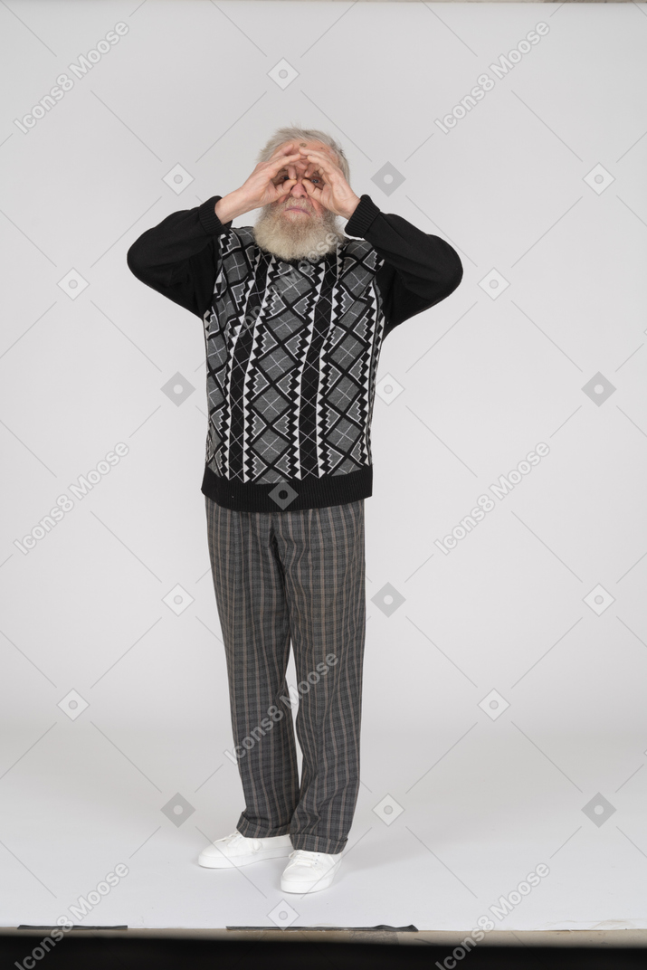 Anciano mirando binoculares de mano