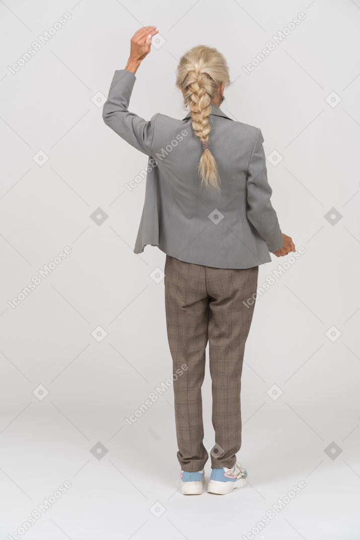 Rückansicht einer tanzenden alten dame im anzug
