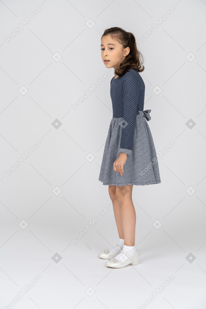Side view of a girl slouching slightly while looking to the side