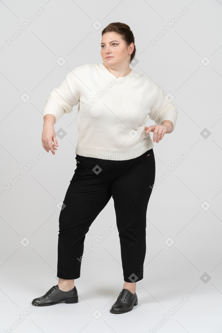 Serious plump woman in white sweater posing
