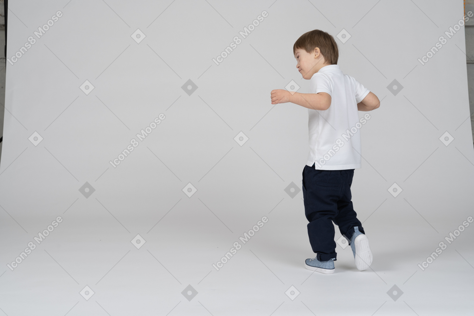 Вид сзади с поворотом в три четверти: мальчик делает шаг вперед со слегка поднятыми руками