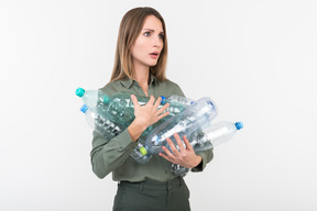 Jovem mulher segurando garrafas de plástico