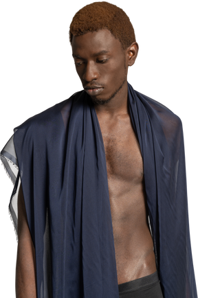 Vista frontal de um jovem afro olhando para baixo com um xale sobre os ombros