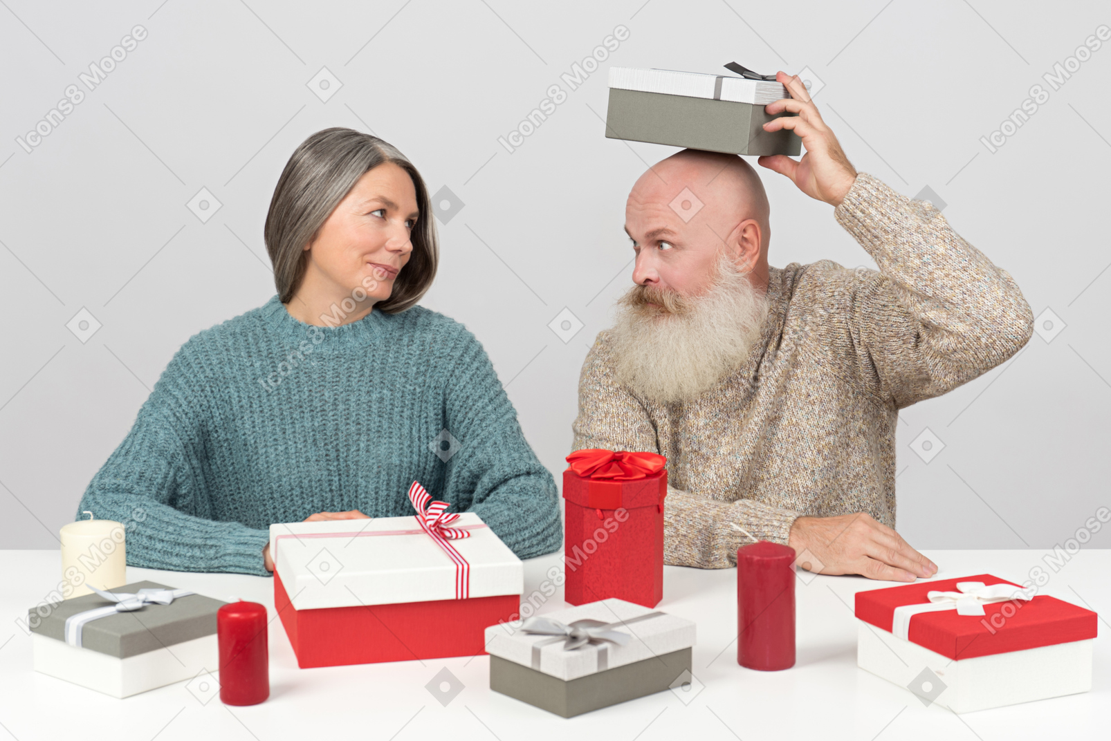Elderly couple packing christmas gifts while husband is fooling around