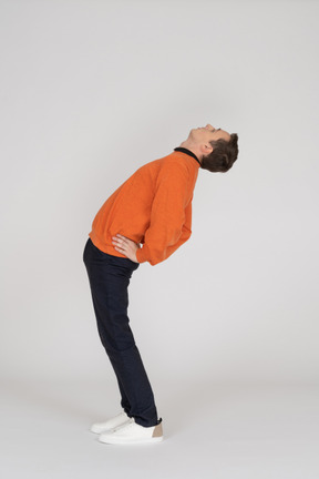 Jeune homme en sweat-shirt orange posant