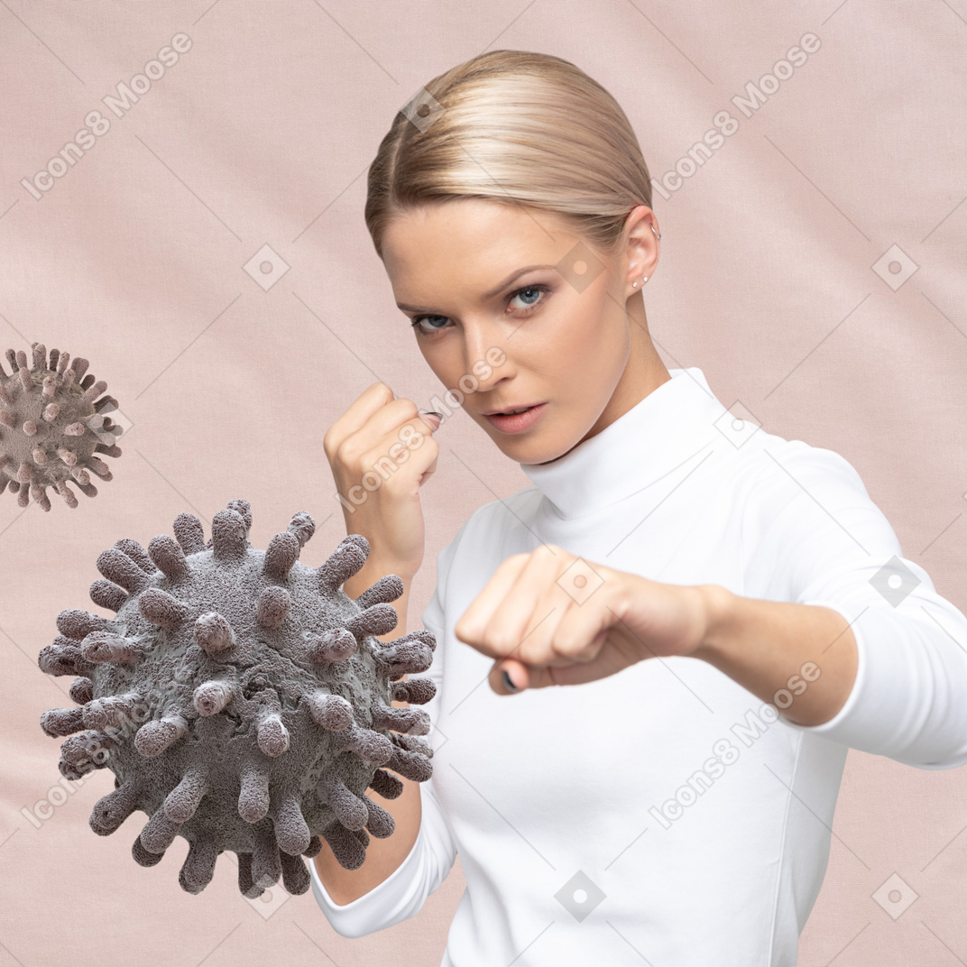 Woman in a fighting position with corovavirus floating in the air