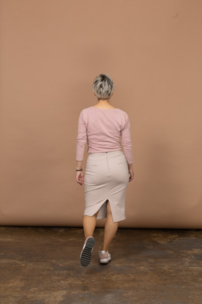 Rear view of a woman in casual clothes walking