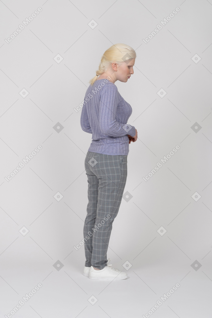 Standing young woman looking down