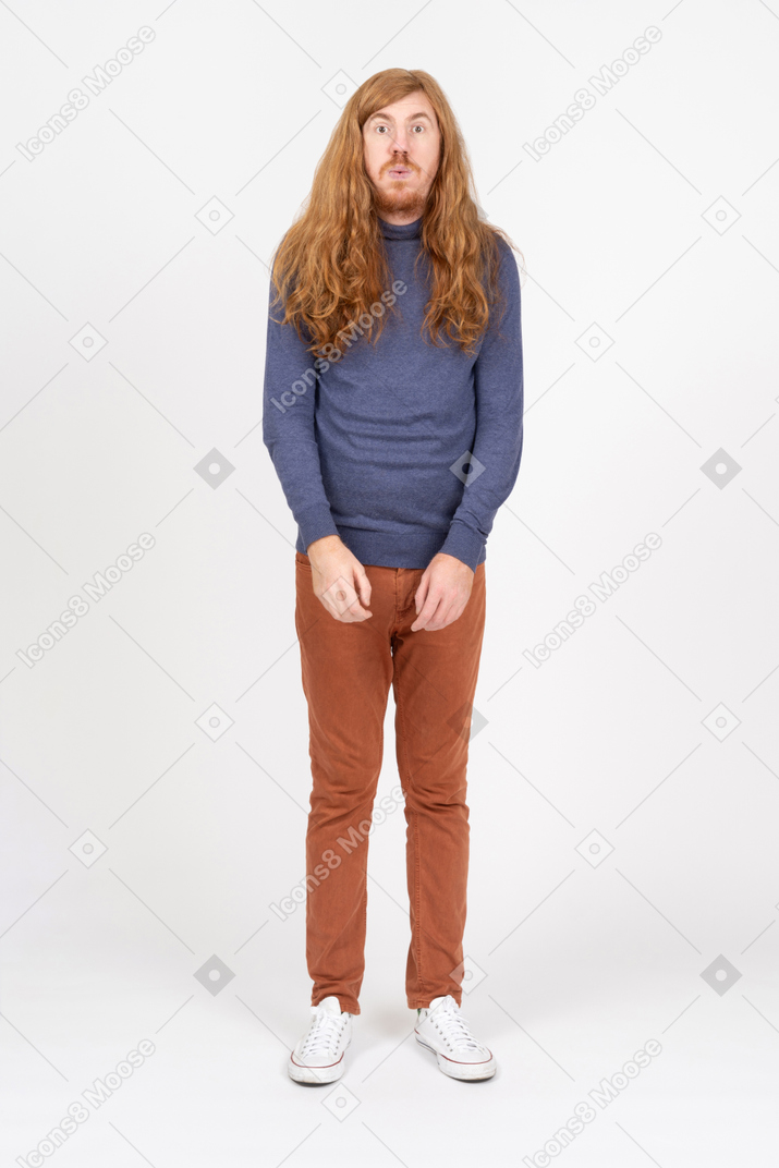 Vista frontal de un joven impresionado con ropa informal mirando a la cámara