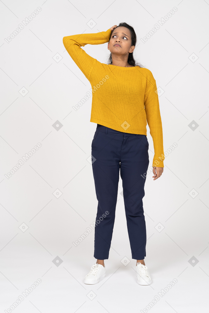 Front view of a girl in casual clothes standing with hand on head and looking up
