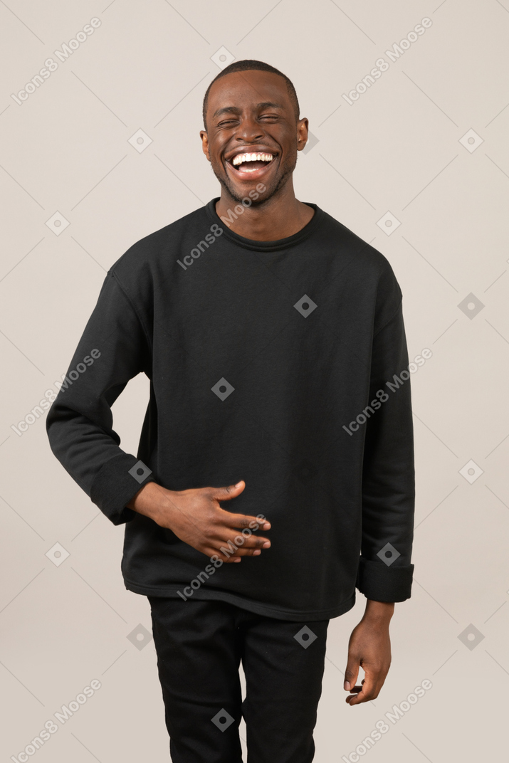 Young man laughing hard and holding his stomach