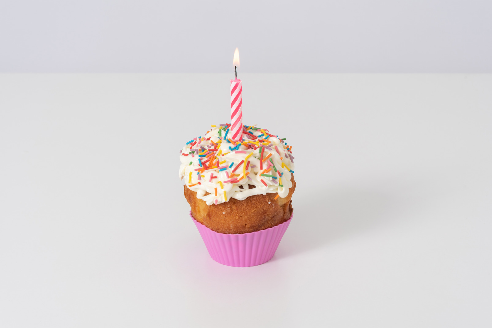 Cupcake with a candle on a white background