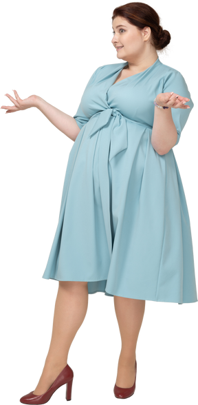 Vista frontal de uma mulher de vestido azul gesticulando