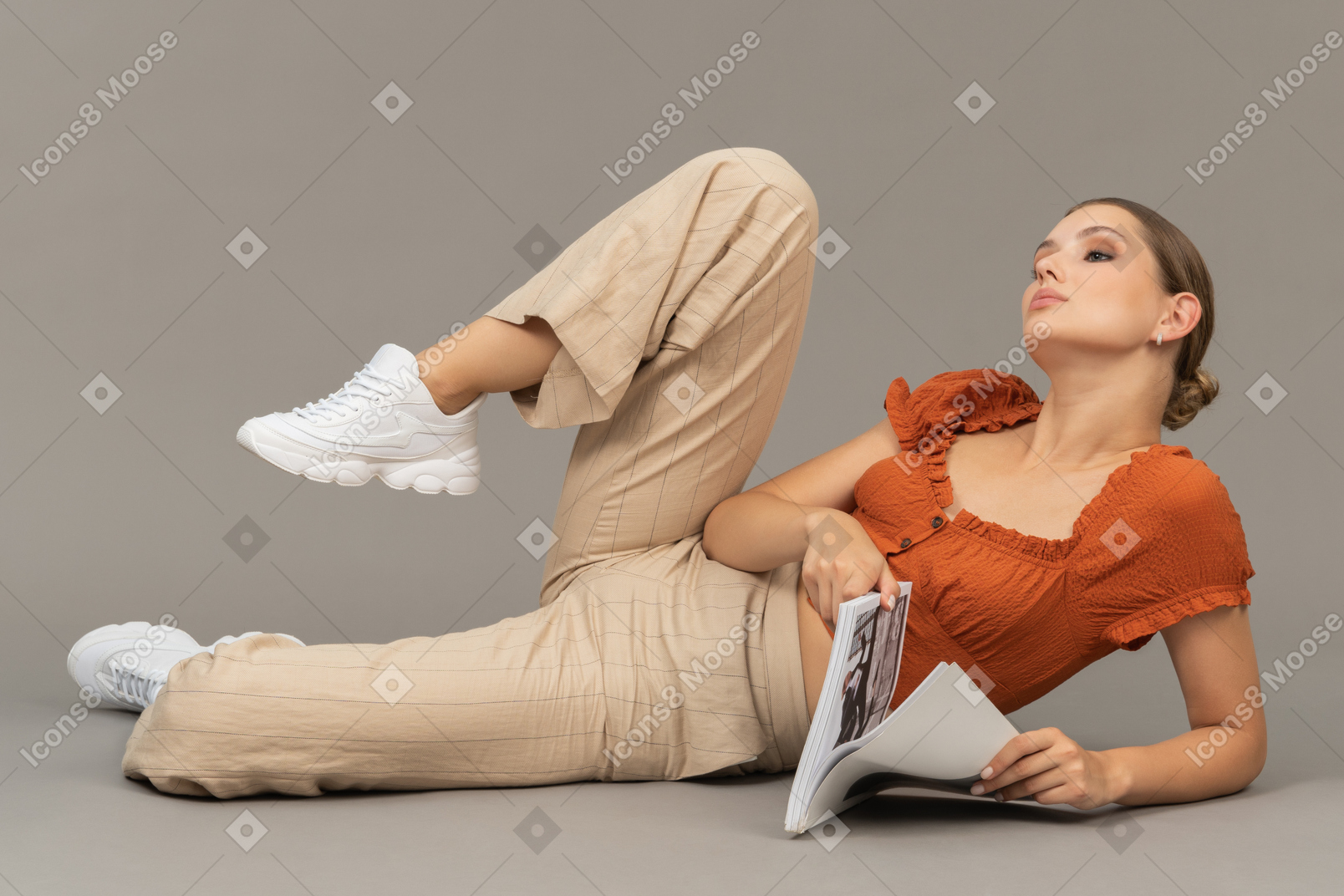 Young woman with a book stretching her leg