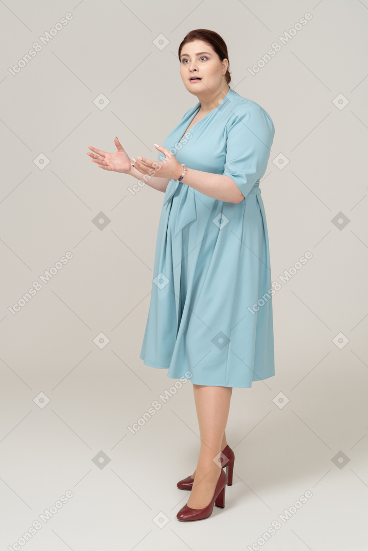 Vista frontal de uma mulher impressionada em um vestido azul