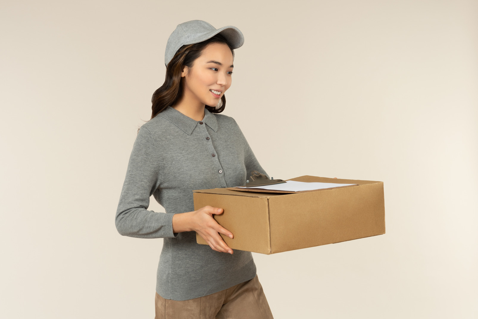 Young asian delivery girl holding box with folder on it