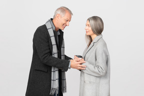 Man warming coffee in woman's hands