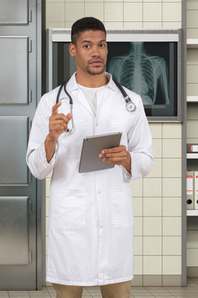 A man in a white lab coat holding a clipboard