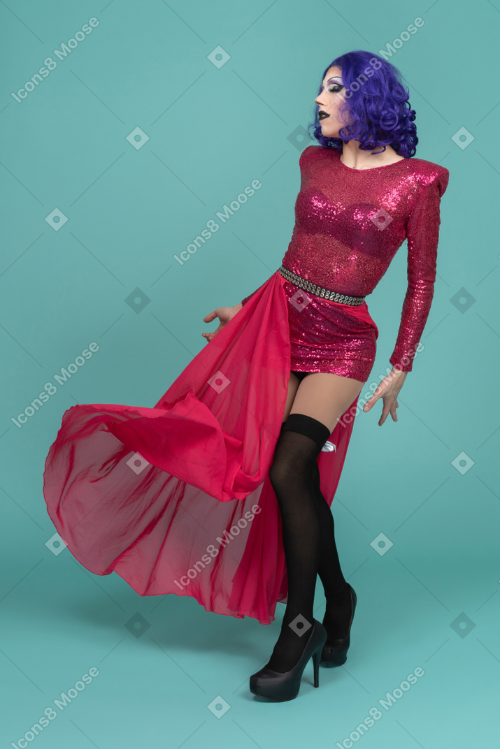 Drag queen in flowing maxi skirt posing with arms at sides