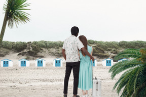 休暇中の若い異人種間のカップルの背面図
