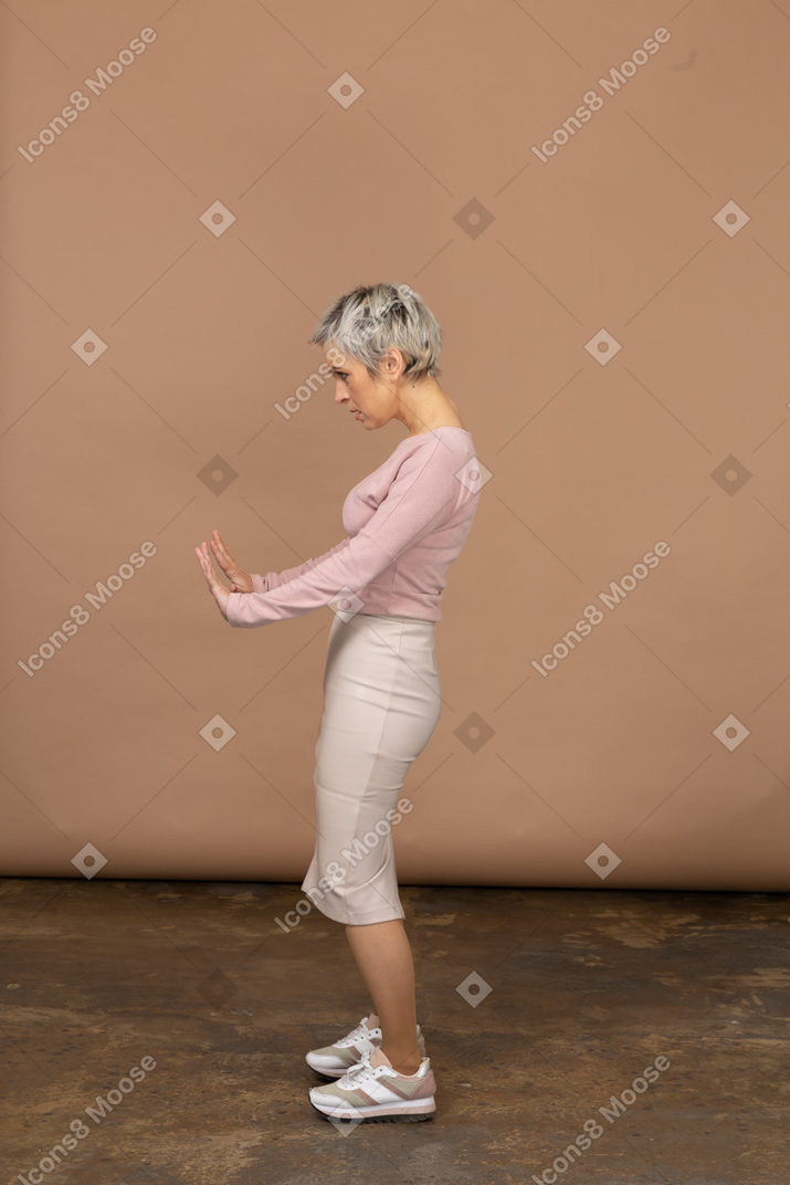 Vue latérale d'une femme en vêtements décontractés montrant un geste d'arrêt