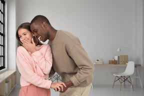 Young interracial couple hugging and laughing 