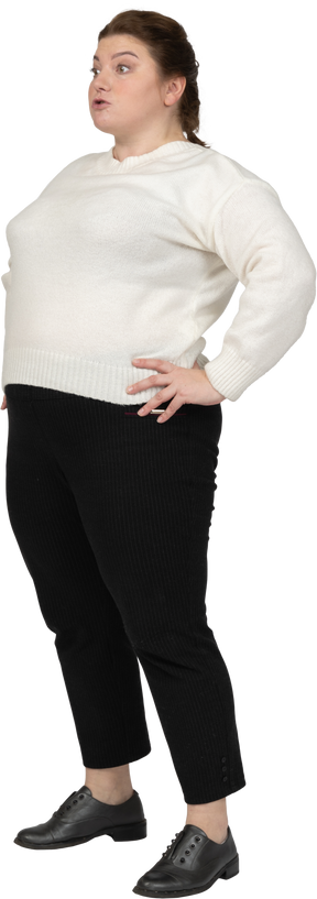Vista laterale di una donna grassoccia in abiti casual in piedi con le mani sui fianchi