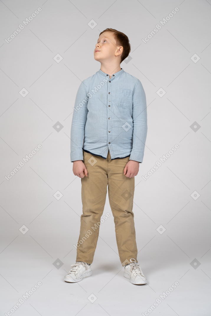 Vista frontale di un ragazzo in abiti casual alzando lo sguardo