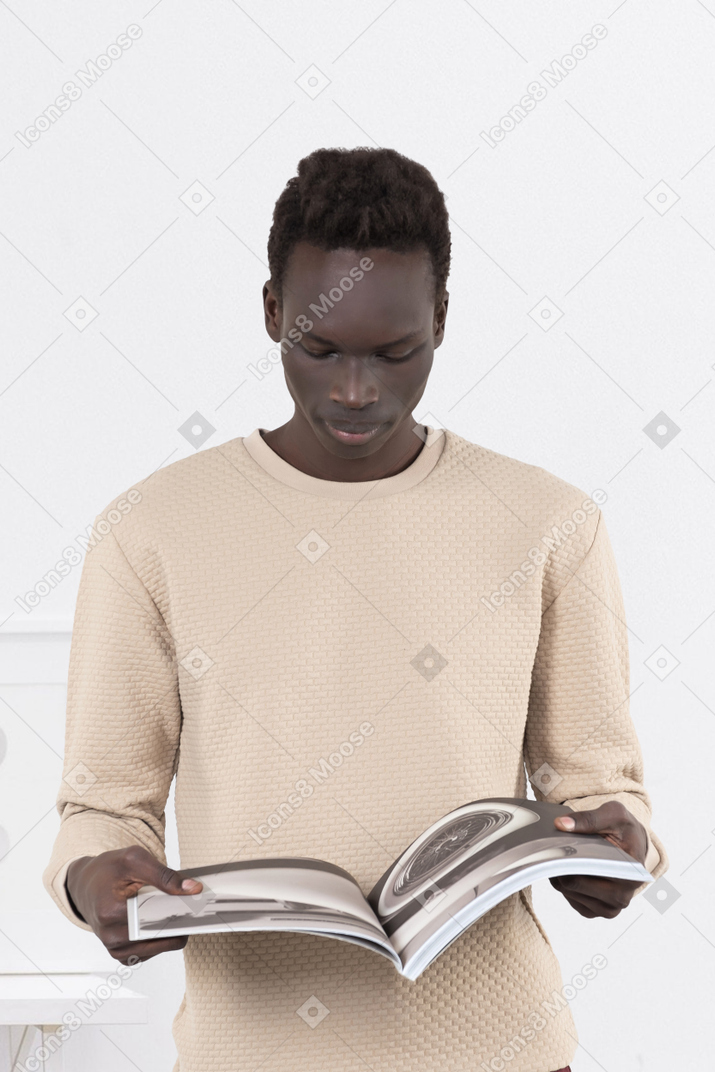 A man reading a book in a white room
