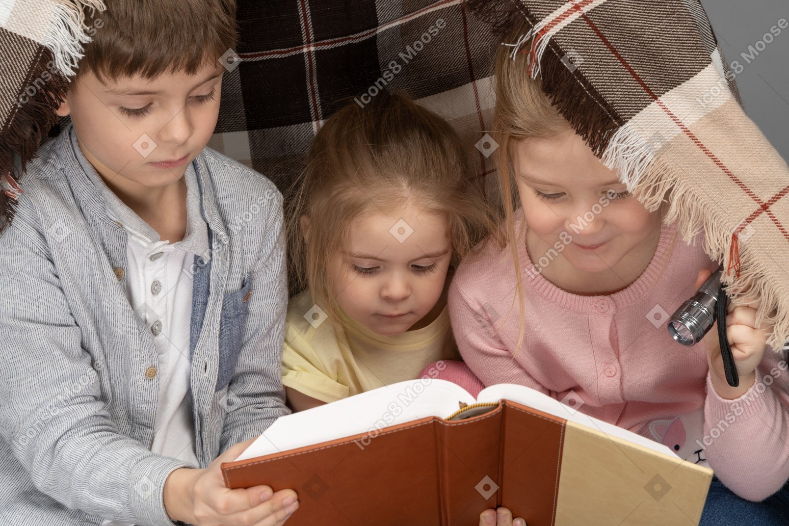 Kids reading a book in a hut