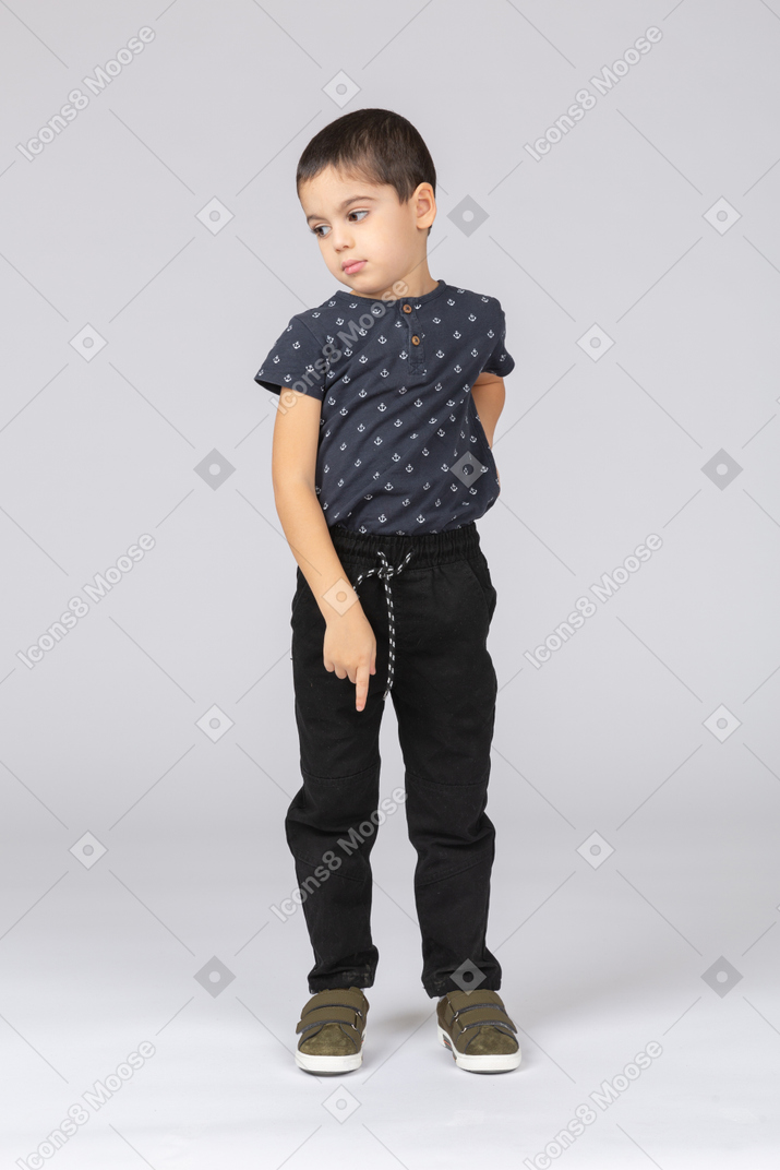 Vista frontal de un chico lindo apuntando hacia abajo con un dedo