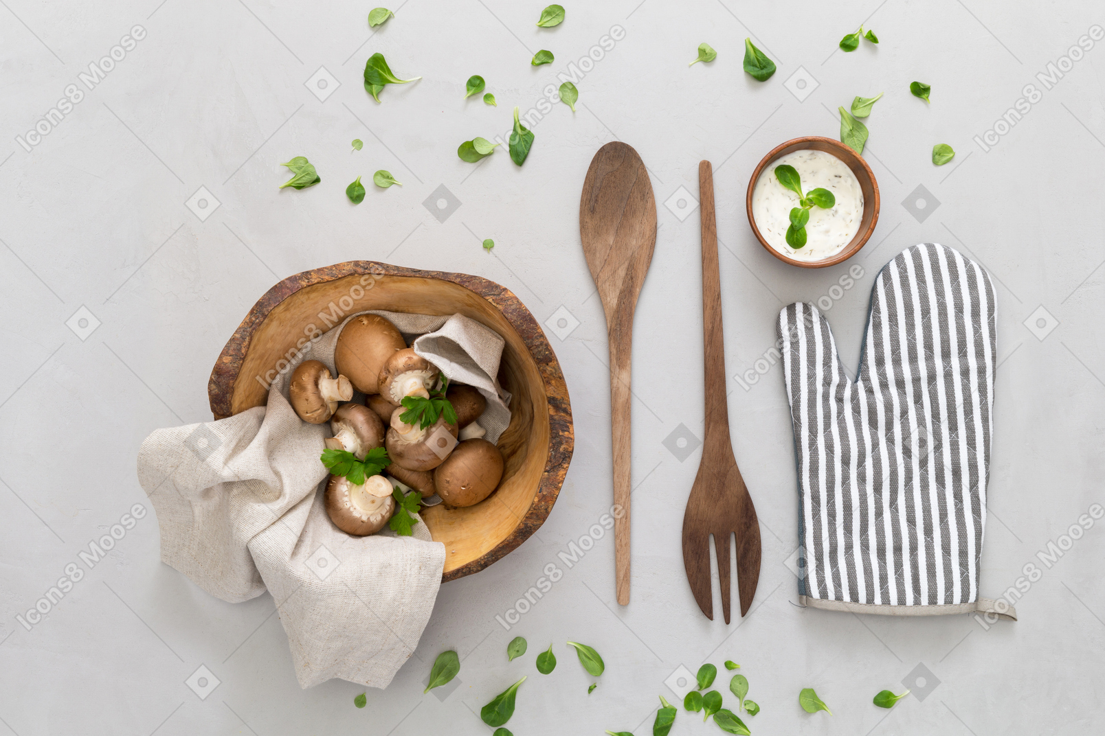 Mushrooms in wooden bowl, wooden cutlery, spices and oven glove