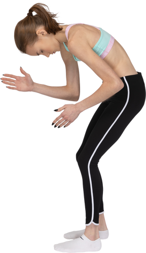 Side view of a teen girl in sportswear bending over and raising her hands